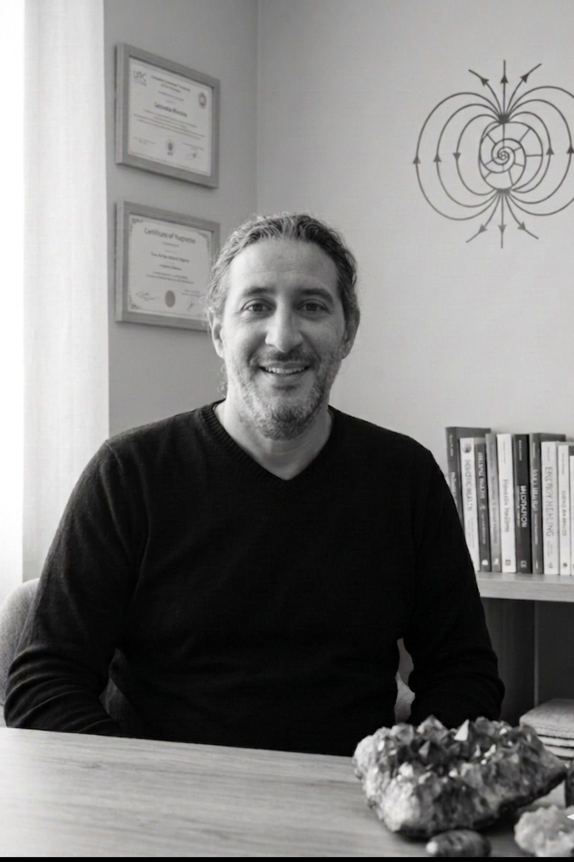 Fouad, magnétiseur et énergéticien à Morsang-sur-Orge en Essonne, dans son espace de pratique avec ses certificats Reiki et sa bibliothèque sur les soins énergétiques